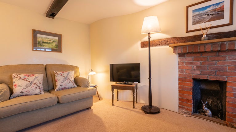 The sitting and dining room, with ornamental fireplace at 1 Compton Farm Cottages, Isle Of Wight